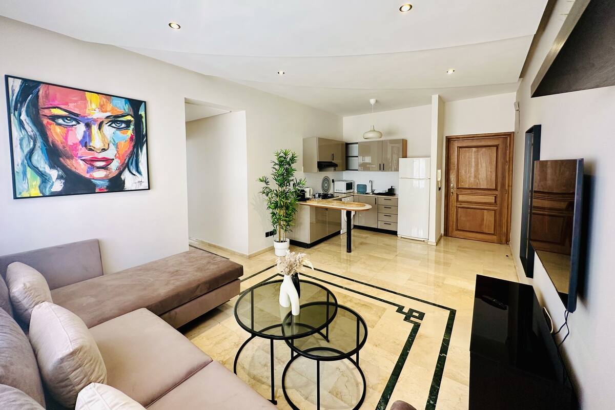 Un salon moderne avec un canapé, une table basse et un tableau au mur.