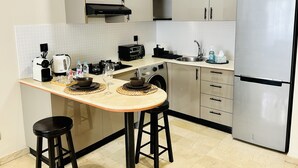 A compact kitchen with a built-in microwave, toaster, sink, and stainless steel refrigerator. - La Perle de Gauthier  by StayInMorocco (Casablanca)