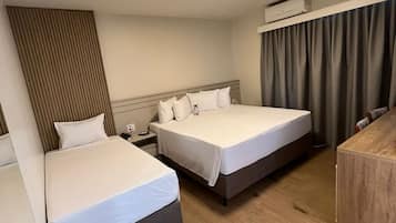 Minibar, escritorio, cortinas blackout y tabla de planchar con plancha