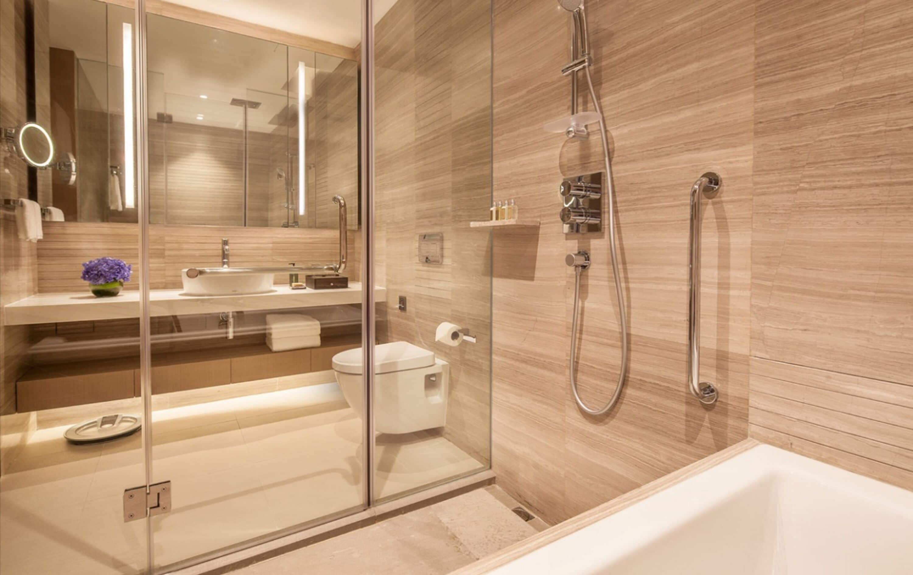Ein modernes Badezimmer mit Duschkabine aus Glas, freistehender Badewanne und Waschtisch mit Spiegel und Waschbecken.