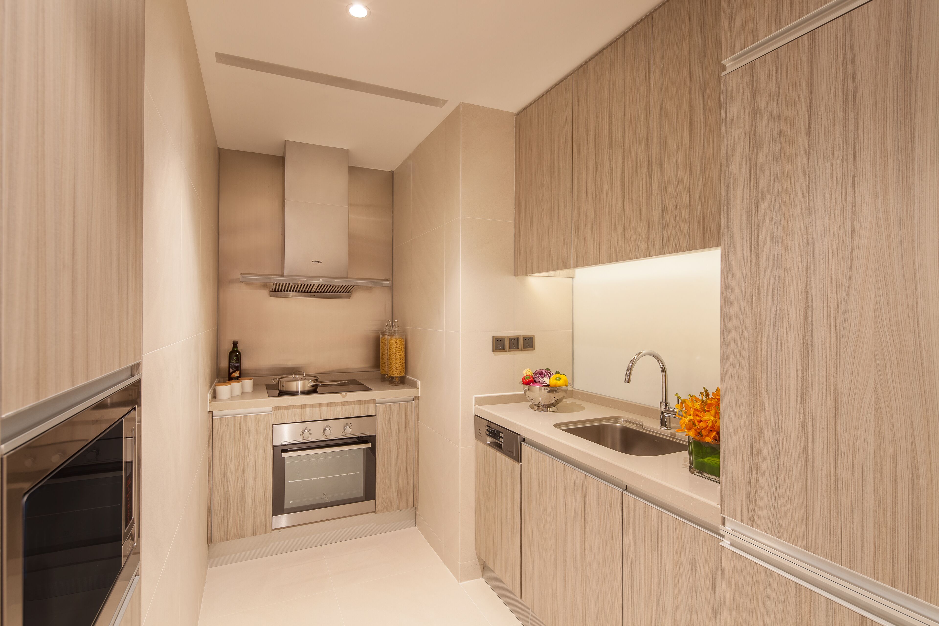 A modern kitchen with wooden cabinets, stainless steel appliances, and a built-in oven.