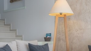 A modern living room with a sofa set, a floor lamp, and a textured wall. - Valea Villa (Naxos)