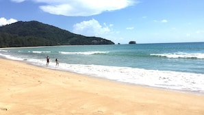 A beach with clear skies, calm waters, and a forested hill in the background. - Slowlife Beach - Hostel (Sa Khu)