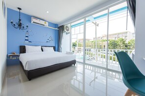 A modern hotel room with a large bed, a chandelier, an air conditioning unit, and a balcony with a view of the city. - Slowlife Beach - Hostel (Sa Khu)