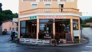 Un edificio de dos plantas con un cartel que indica que es un restaurante y hotel.