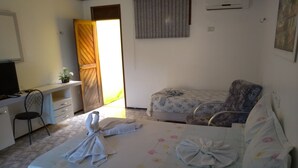 Una habitación de hotel con cama, escritorio, silla y ventana.
