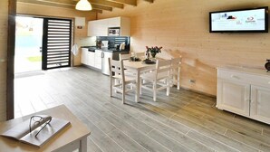 Een moderne keuken met witte kasten en een eethoek met een tafel en stoelen.