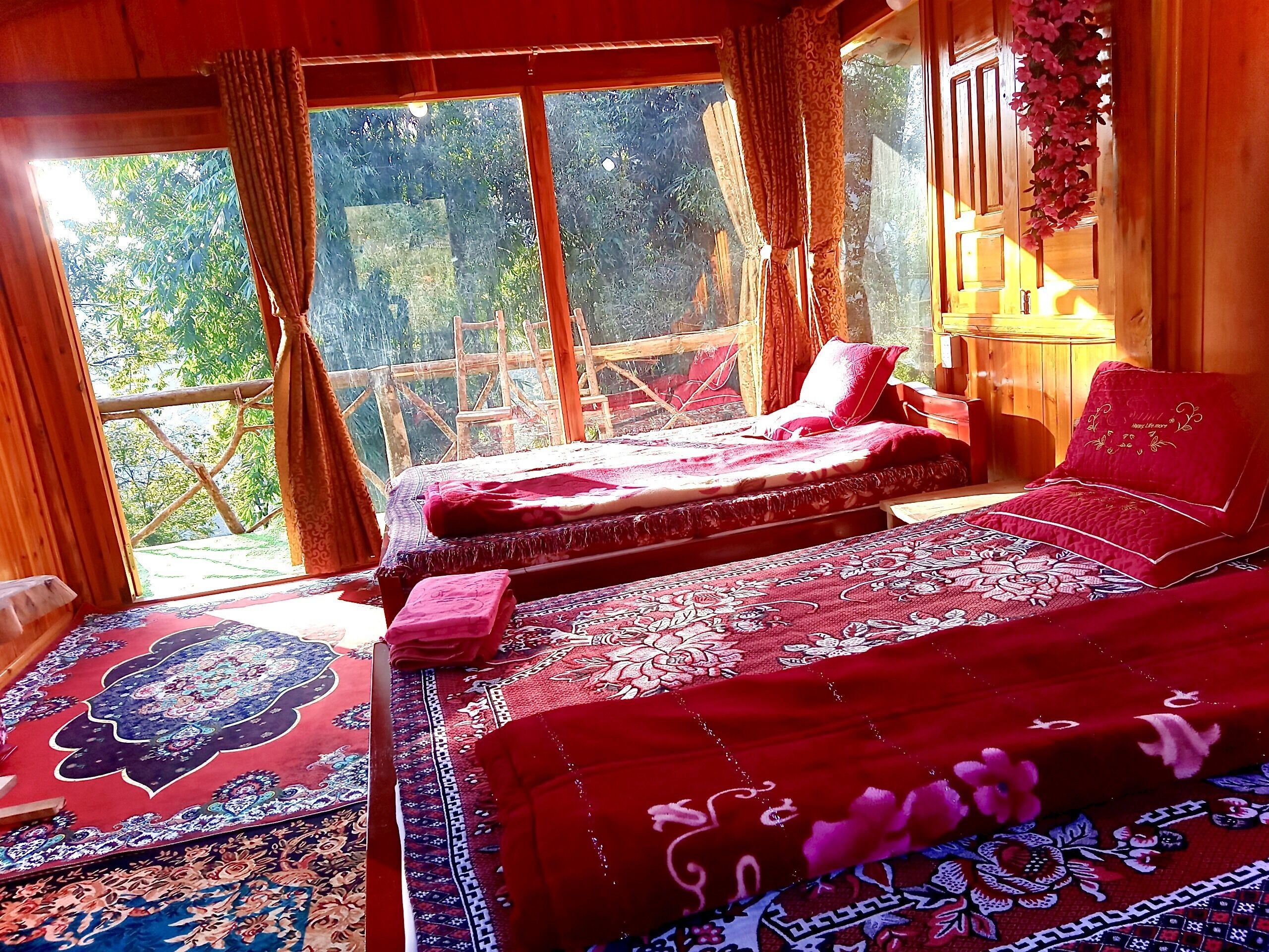 Una habitación con cama, una silla y vistas al verdor exterior.