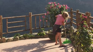 A person cleaning a wooden fence with a broom. - Freedom Homestay (Ta Van)