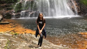 A waterfall with a person standing in front. - Freedom Homestay (Ta Van)