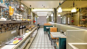 A modern restaurant interior with a patterned floor, seating areas, and a buffet setup. - Hotel Kalpana Palace (Mumbai)