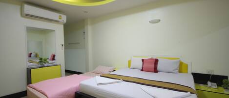 A modern hotel room with a bed, bedside table, and a mirror.