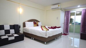 A hotel room with a bed, a sofa, a sliding glass door, and an air conditioning unit. - Windsor Park and Resort (Lop Buri)