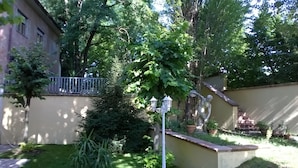 A garden with a white fence, a statue, and a lamp post. - Villa Cardinal Apartments (Tivoli)