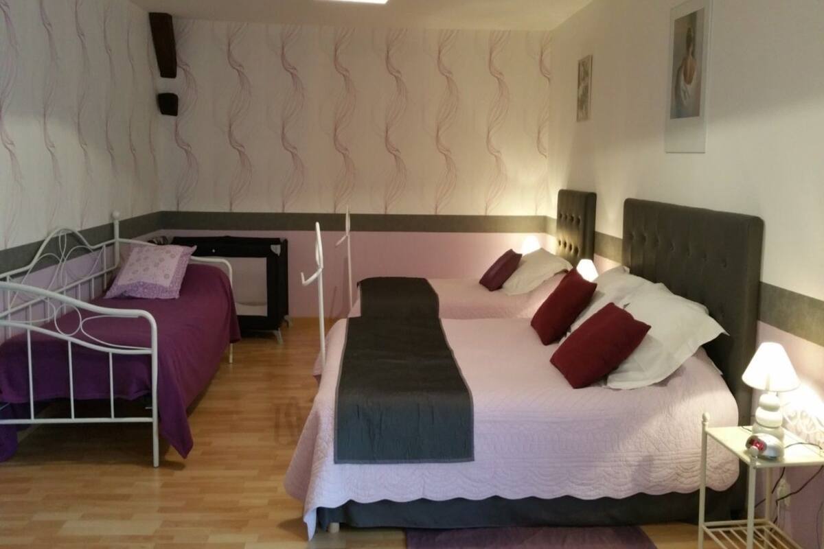 A bedroom with a single bed, a desk, and a chair.
