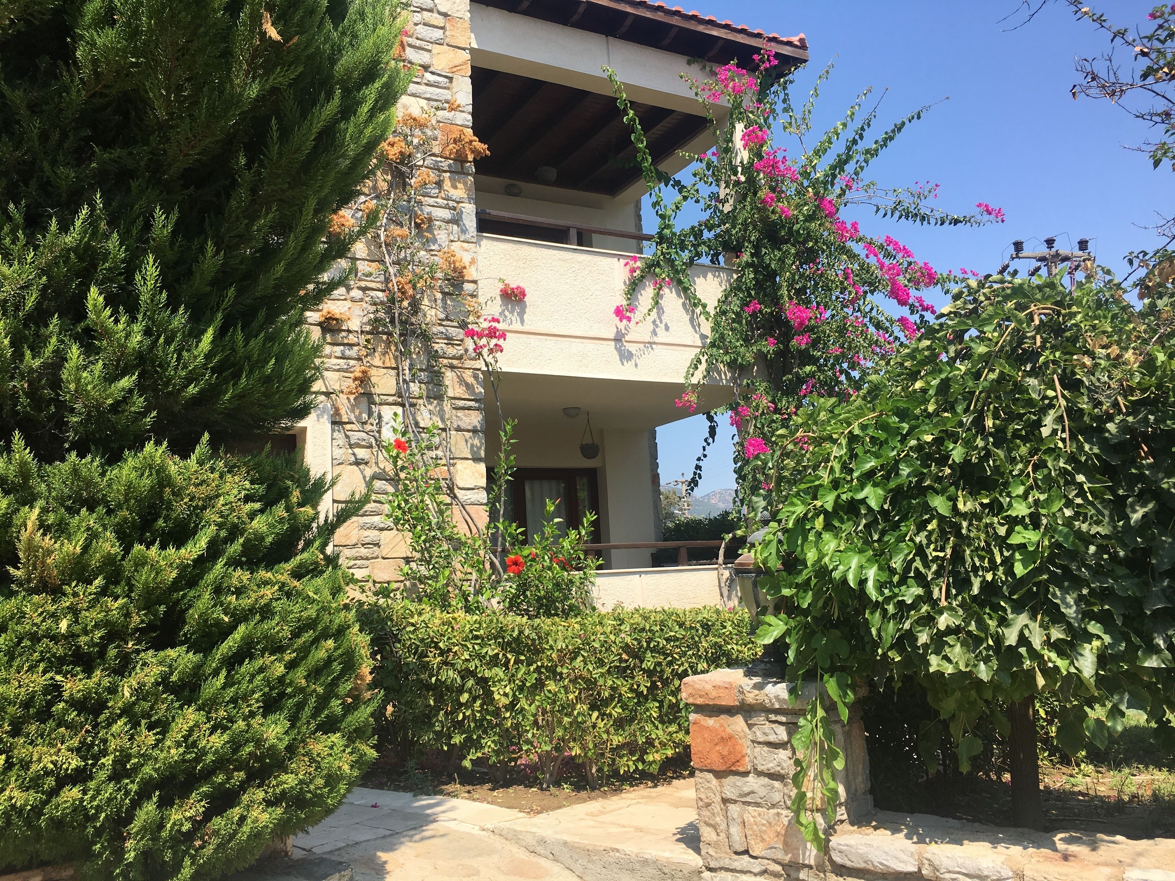 A two-story building with stone walls and a balcony.