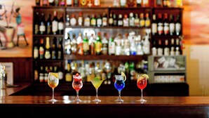 A bar with a variety of colorful cocktails on the counter. - Keys Hotel (Moshi)