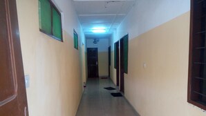 A hallway with tiled flooring, doors on both sides, and a ceiling light.