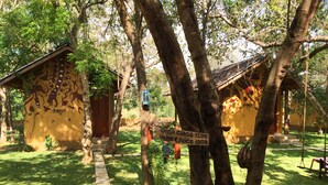 A yoga class sign in a garden with trees and a pathway. - Sat Nam Village Hotel (Avudangawa)