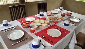 A table set for breakfast with various dishes, including toast, fruit, and a beverage.