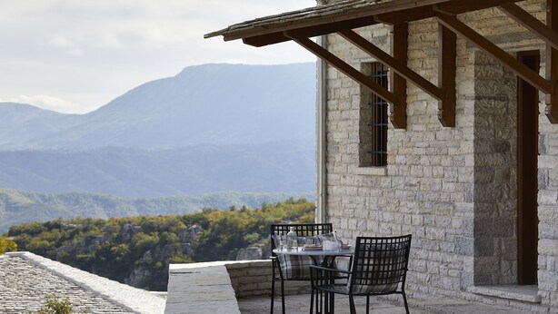A stone building with a balcony overlooking a mountainous landscape. - MounTrace Suites & Spa (Zagori)