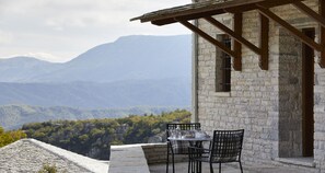 A stone building with a balcony overlooking a mountainous landscape. - MounTrace Suites & Spa (Zagori)
