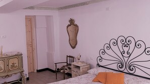 Ein Schlafzimmer mit Bett, Schminktisch, Stuhl und Spiegel.