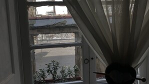 Eine Tür mit Blick auf eine Straße und ein Balkon mit Pflanzen.