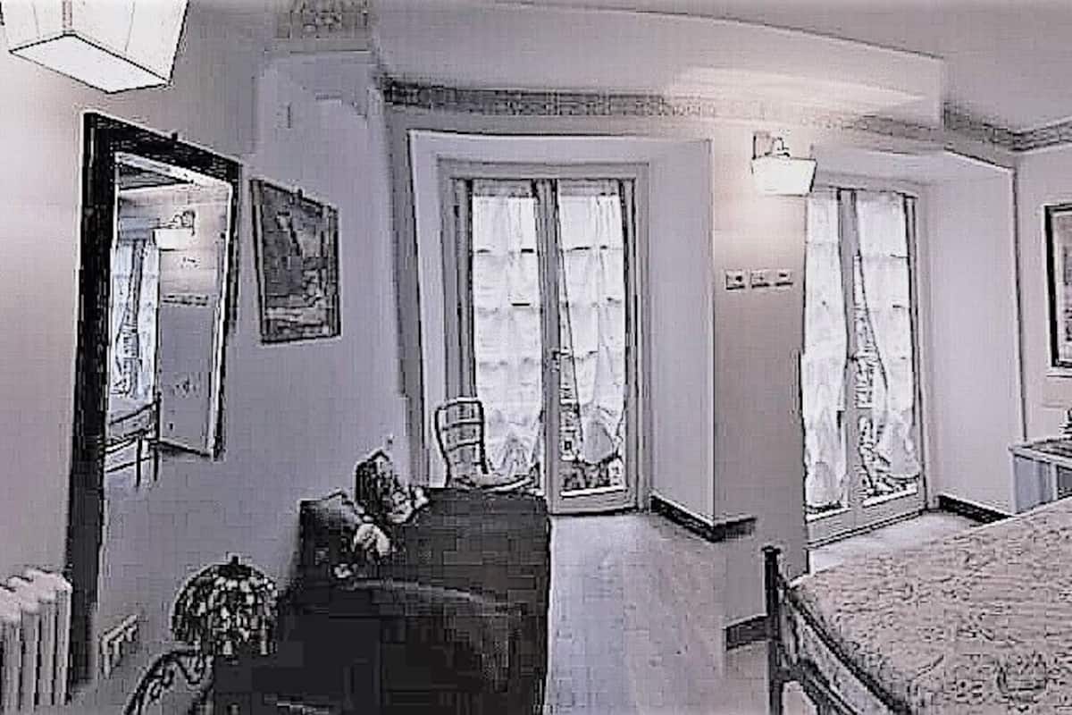 A bedroom with a bed, a nightstand, a chair, a wardrobe, and a ceiling fan.