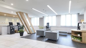 A modern hotel reception area with a check-in counter, seating area, and large windows. - SHIZUTETSU HOTEL PREZIO Hakata-Ekimae (Fukuoka)
