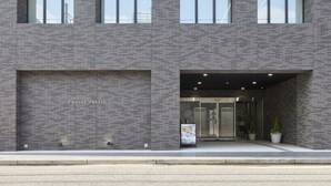 A modern building with a brick facade, large windows, and a glass entrance. - SHIZUTETSU HOTEL PREZIO Hakata-Ekimae (Fukuoka)