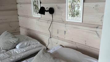 Een slaapkamer met twee bedden, elk voorzien van een kussen en een wandlamp.