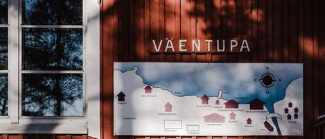Puiseen seinään on kiinnitetty kyltti, jossa on kartta ja teksti ”VAENTUPA”.
