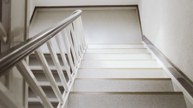 A staircase with white steps and a metal handrail. - Glück Auf Appartements See Straße (Essen)