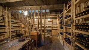 Una bodega rústica con estantes de madera y una escalera central.