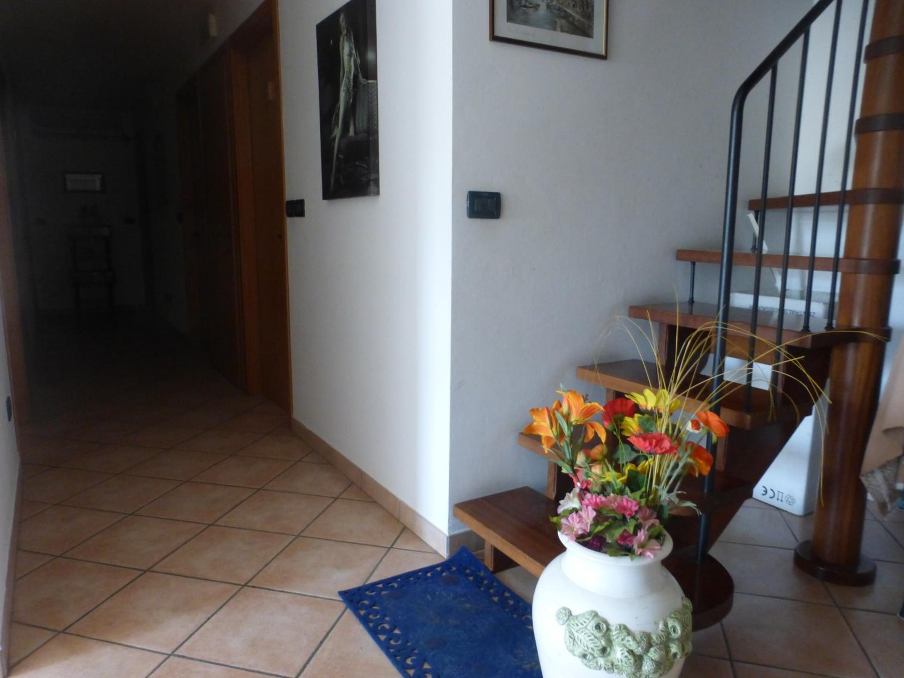 A staircase with a wooden handrail and a blue mat at the bottom.