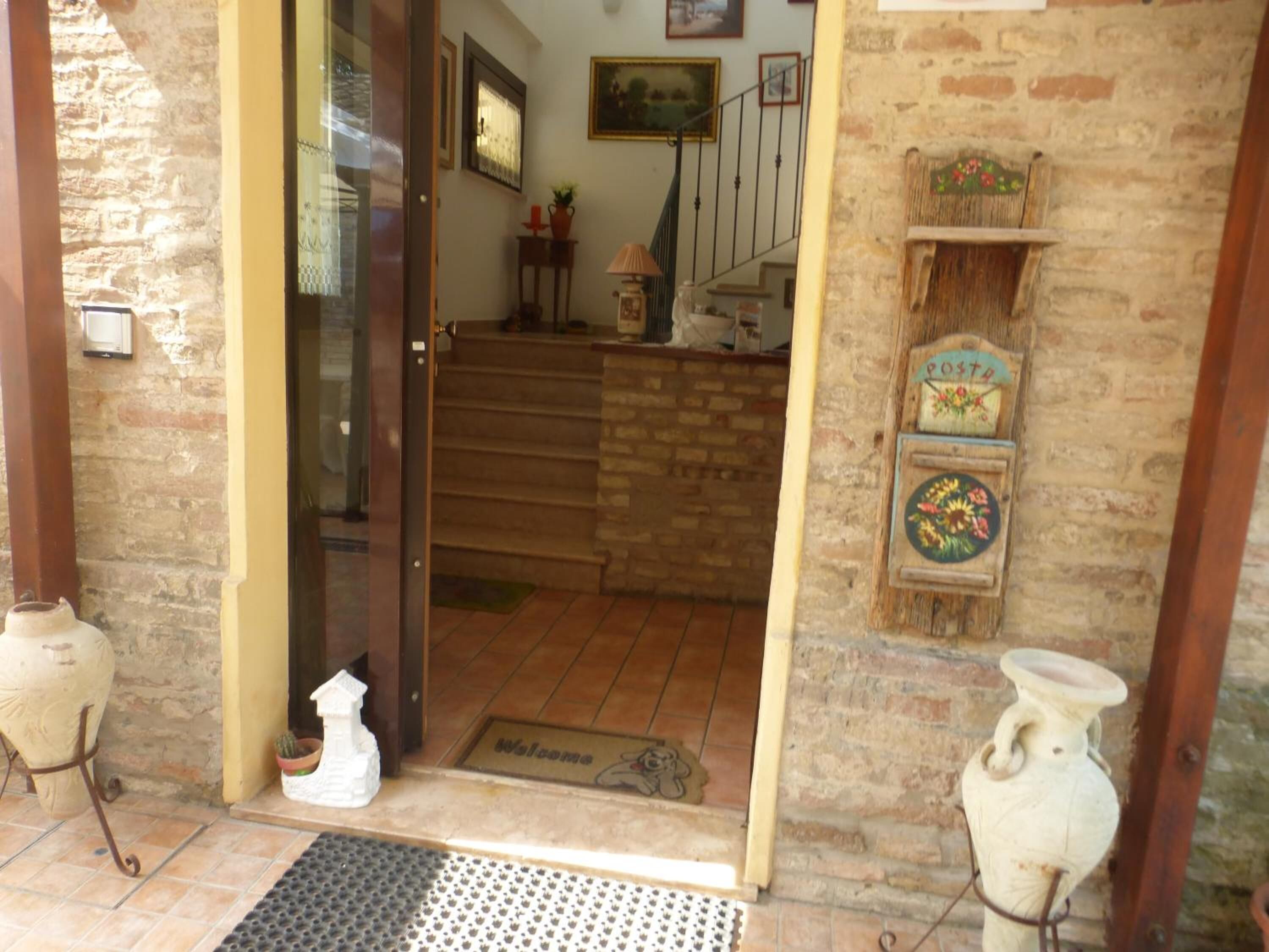 Une entrée rustique avec une porte en bois, un escalier et un paillasson.