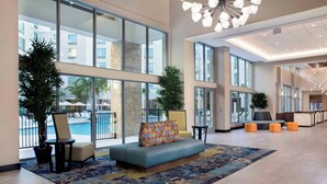 A spacious lobby with a large seating area, a pool view, and modern decor. - SpringHill Suites by Marriott Orlando Theme Parks/Lake Buena Vista (Orlando)