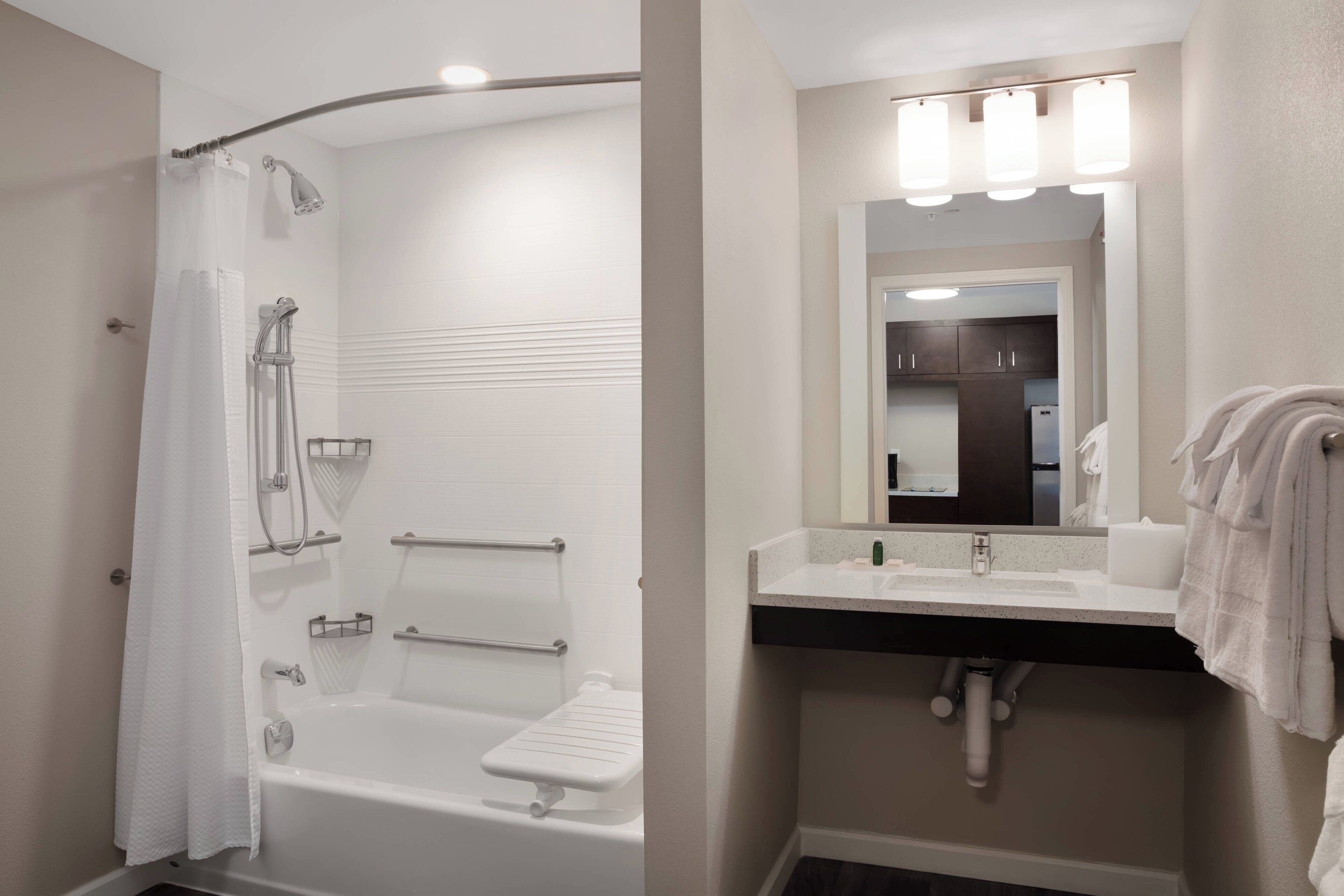 Un baño con ducha, lavabo y espejo.
