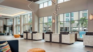 A spacious lobby with a reception desk, seating area, and large windows offering views of the outdoors. - SpringHill Suites by Marriott Orlando Theme Parks/Lake Buena Vista (Orlando)