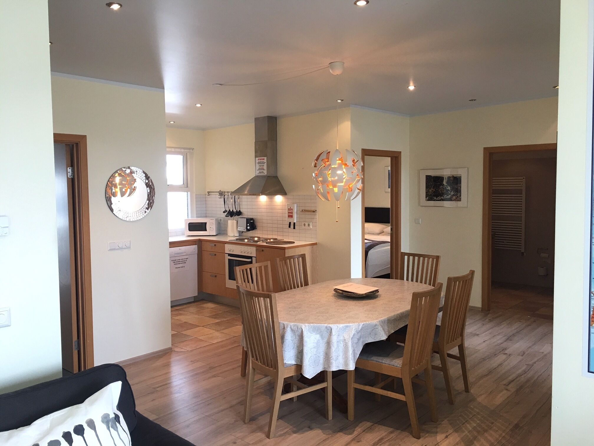A compact kitchen with a dining area, wooden chairs, and a table.
