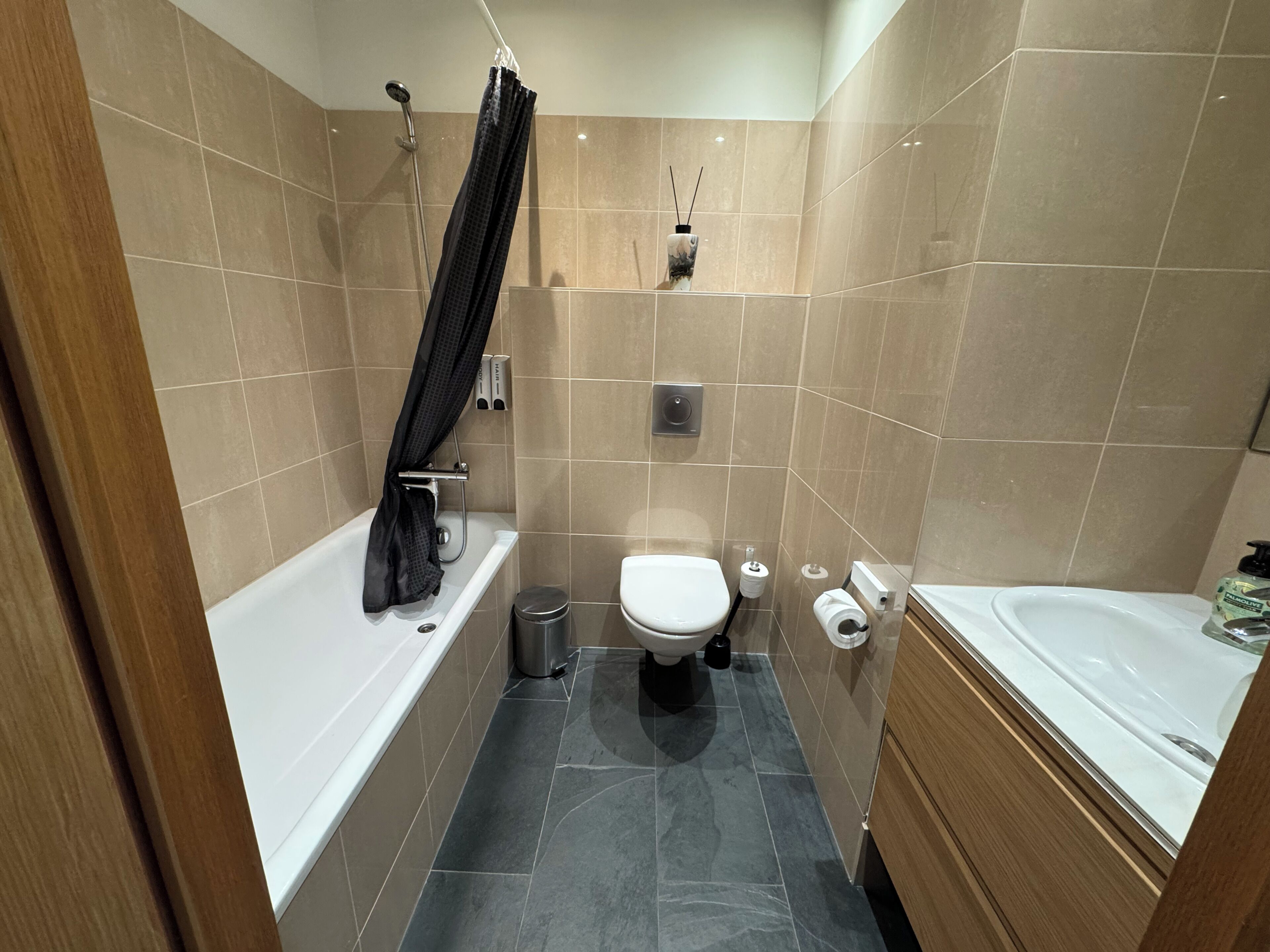 A bathroom with a bathtub, toilet, and sink.