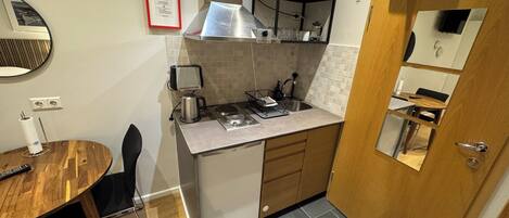 Una cocina compacta con microondas, tostadora y lavaplatos.