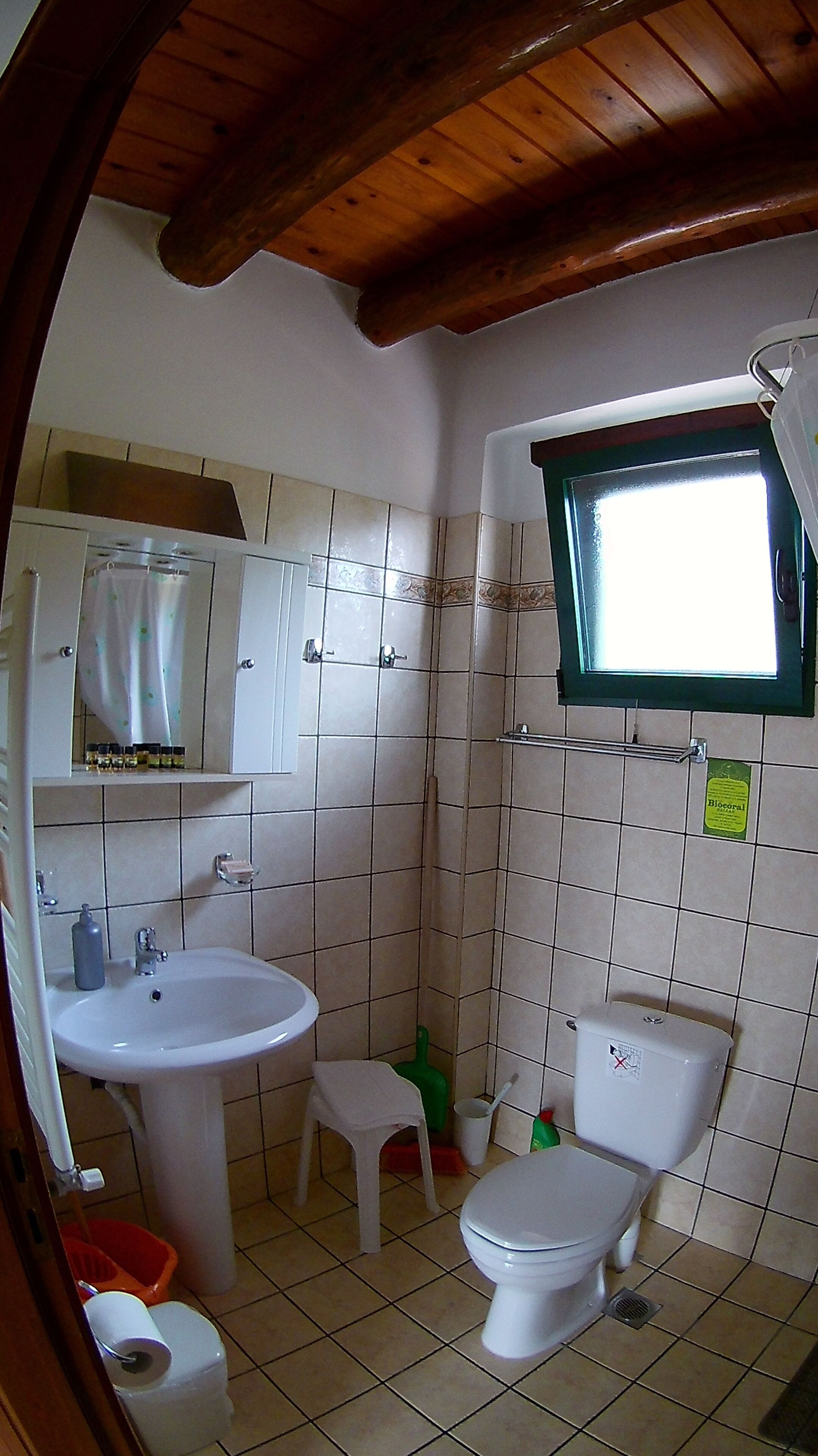 Une petite salle de bain comprenant un lavabo, des toilettes et une petite fenêtre.