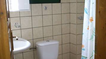 Un baño pequeño con inodoro, lavabo y cubo de basura.