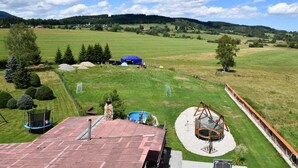 A residential property with a swimming pool, trampoline, and a large open field.