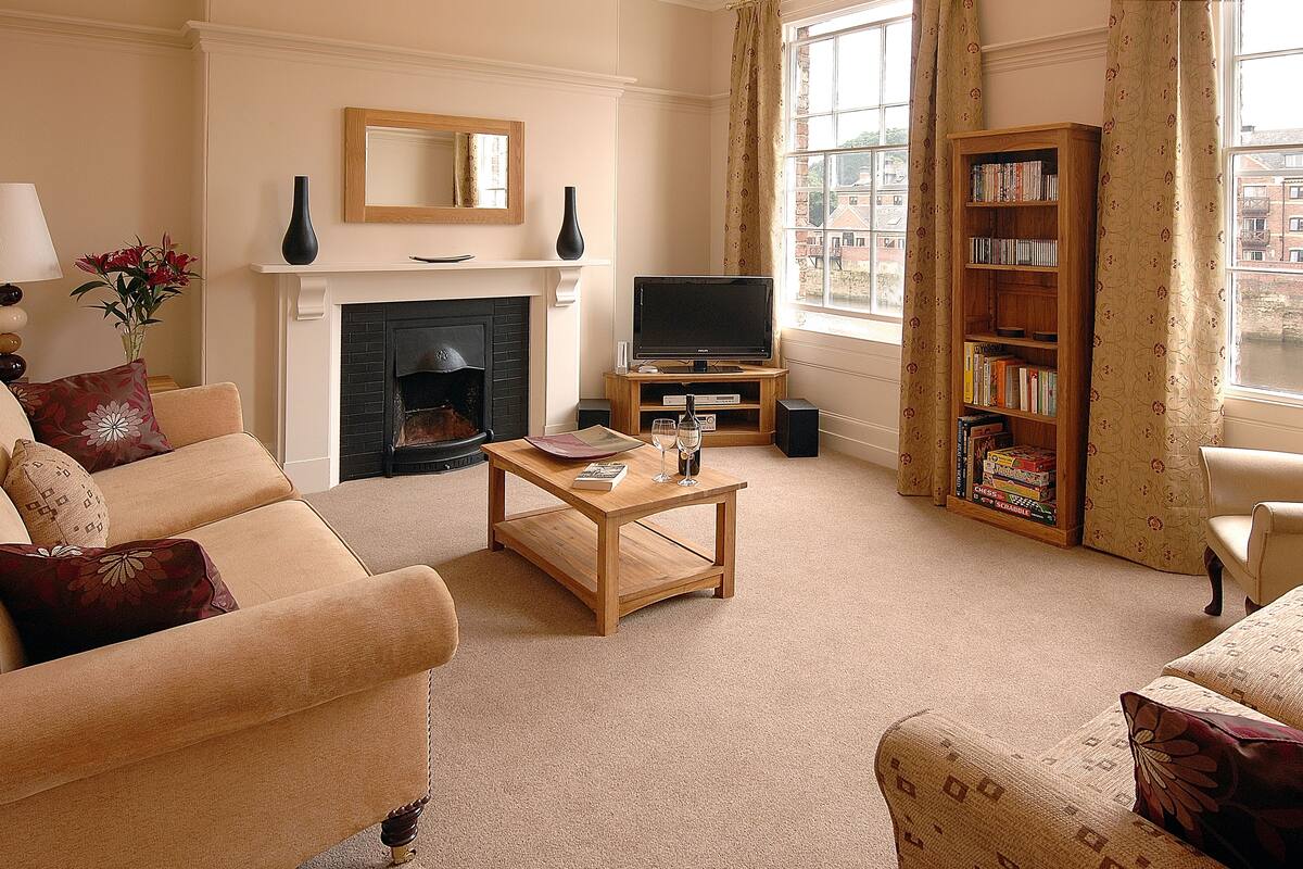 A living room with a fireplace, a television, and a bookshelf.