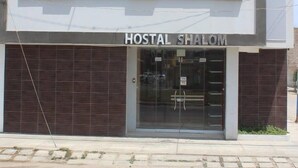A two-story building with the sign "HOSTAL SHALOM" on the roof and at the entrance. - Hostal Shalom (Pisco)