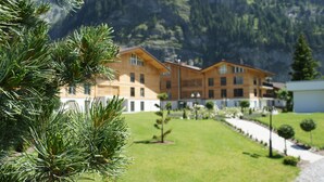 A building with a symmetrical facade, multiple windows, and a central entrance. - Victoria Alpine Park (Kandersteg)