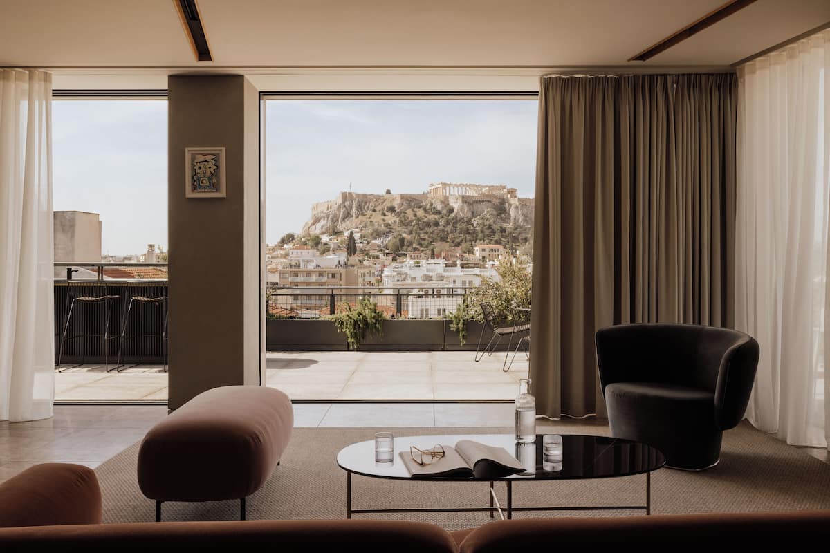 A modern room with a view of a historic hilltop fortress.